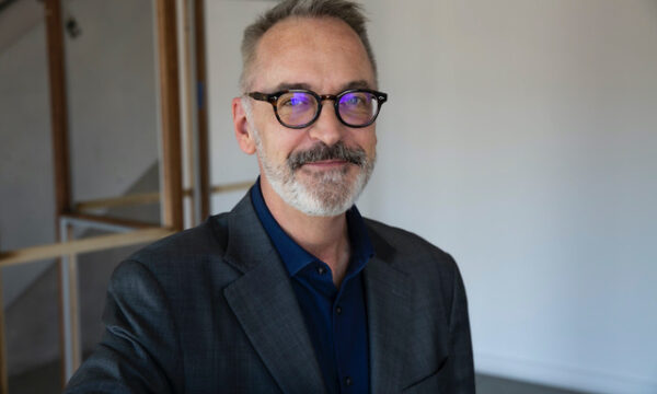 man with salt and pepper hair and beard with dark rimmed glasses