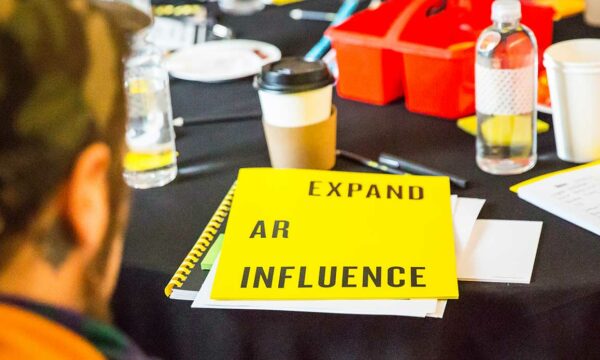 yellow workbook sits on a crowded black table