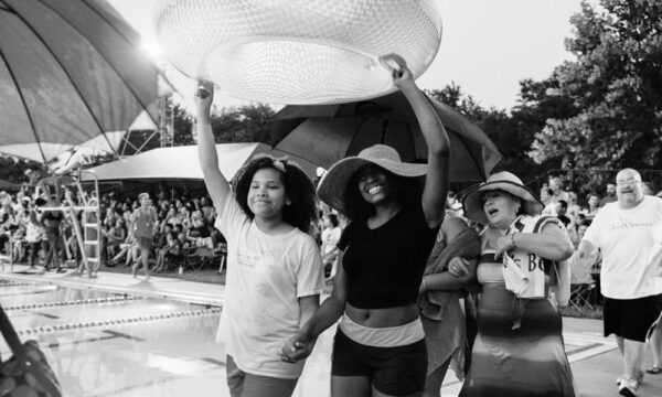 A black and white photo shows people outside celebrating art