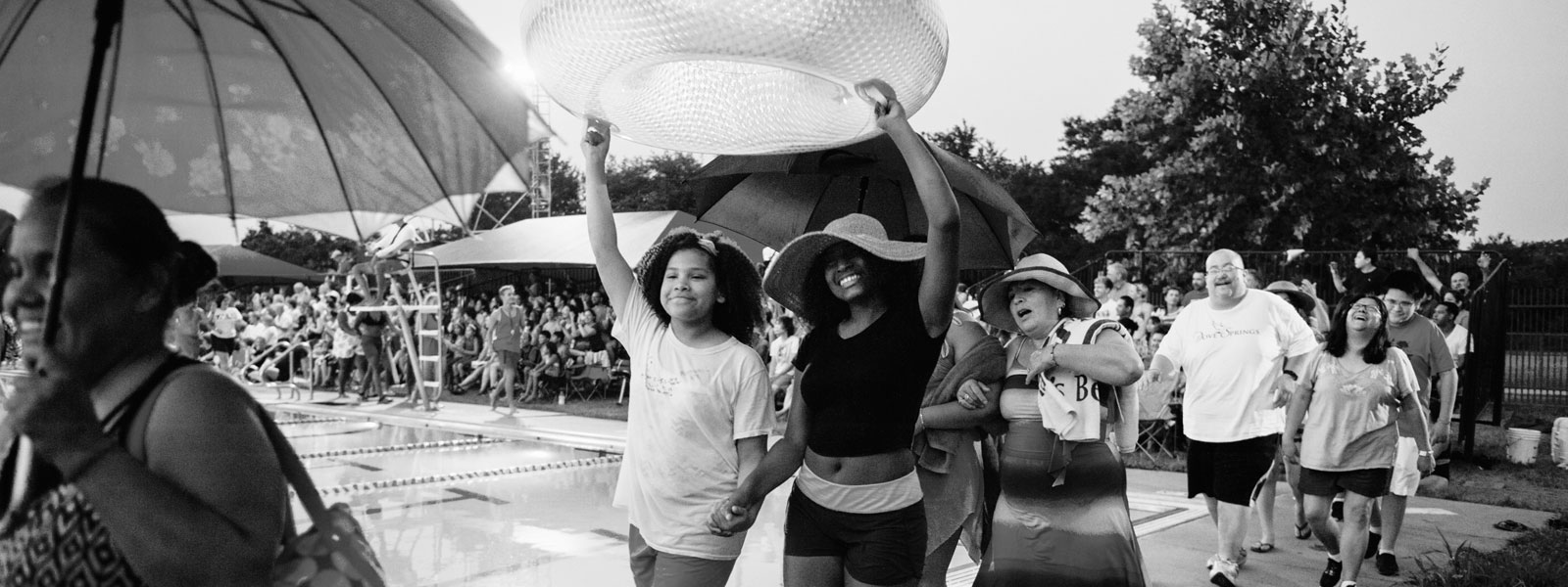 A black and white photo shows people outside celebrating art