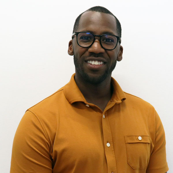 man with dark rimmed glasses and yellow shirt