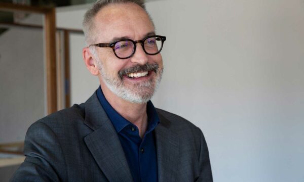 Man with salt and pepper hair and beard with black rim glasses