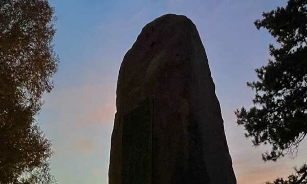 tall rock stands against a sky at dusk