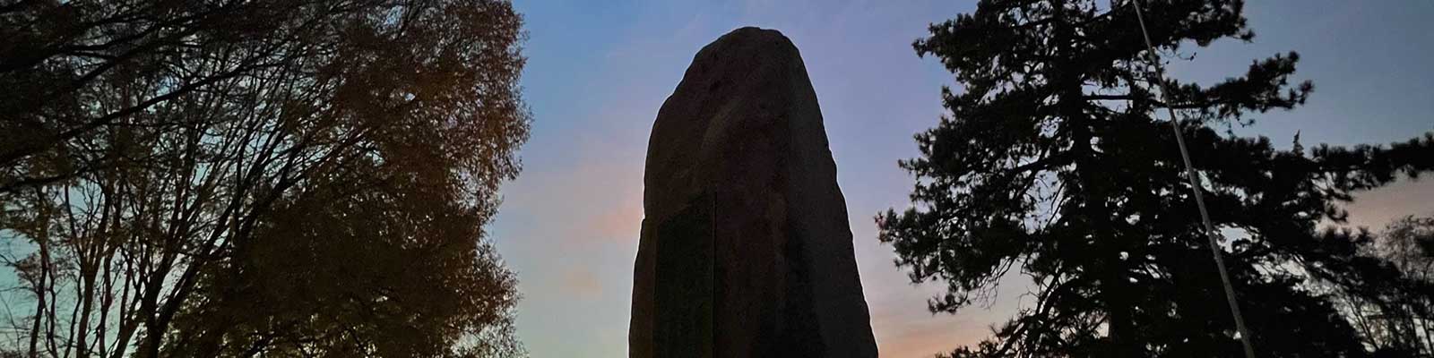 tall rock stands against a sky at dusk