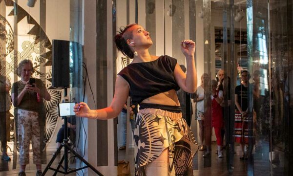 A woman looking up performs in the round