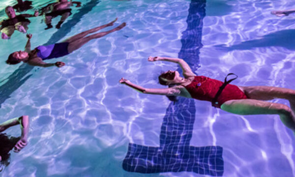 people float in a pool at night