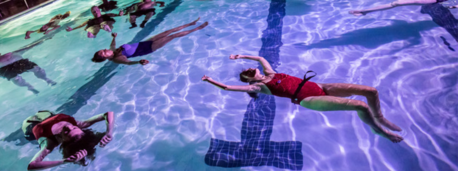 people float in a pool at night