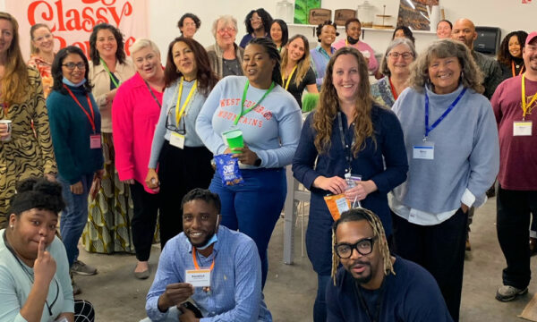 Large group of artists stand together for a group photo.