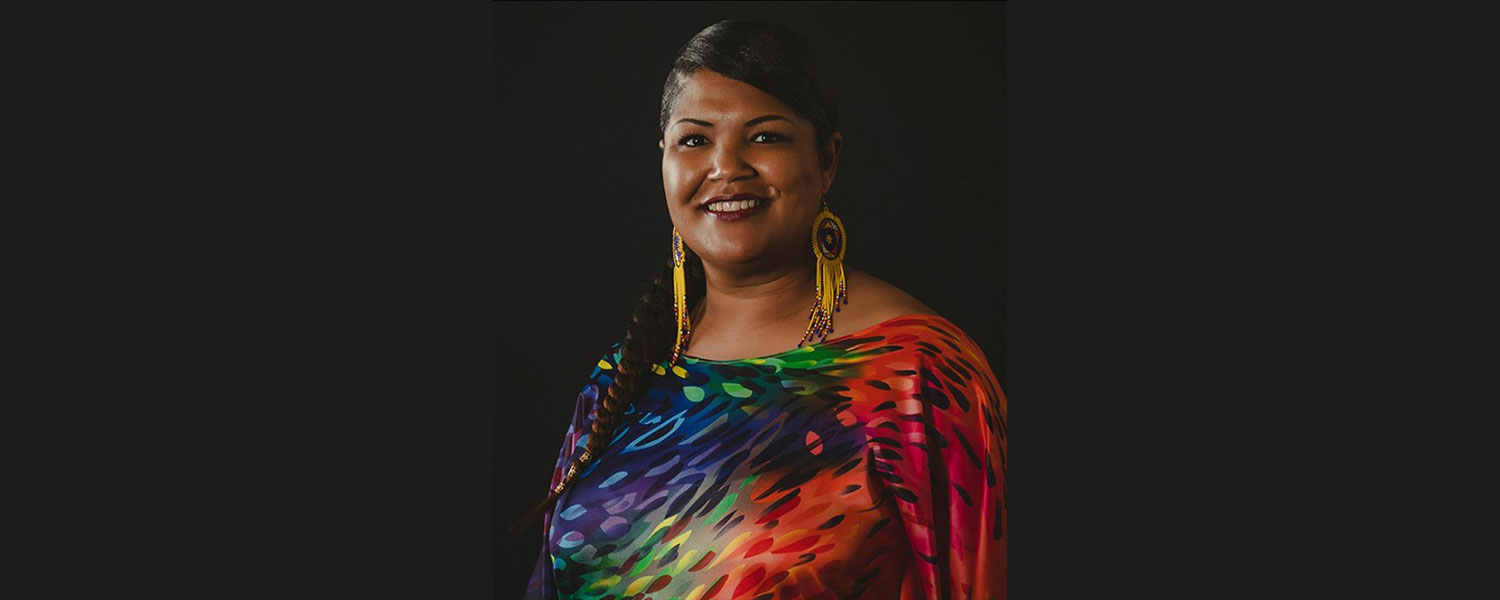 Creative Impact Awardee Lakisha Jackson featured with her headshot where she is smiling and wearing large bright earrings and a colorful blouse.