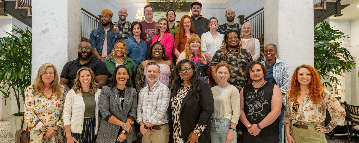 Catalyze grantees pose for group photo in front of a large stairway