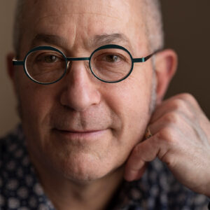 Light skinned man with black rimmed glasses in a headshot portrait.