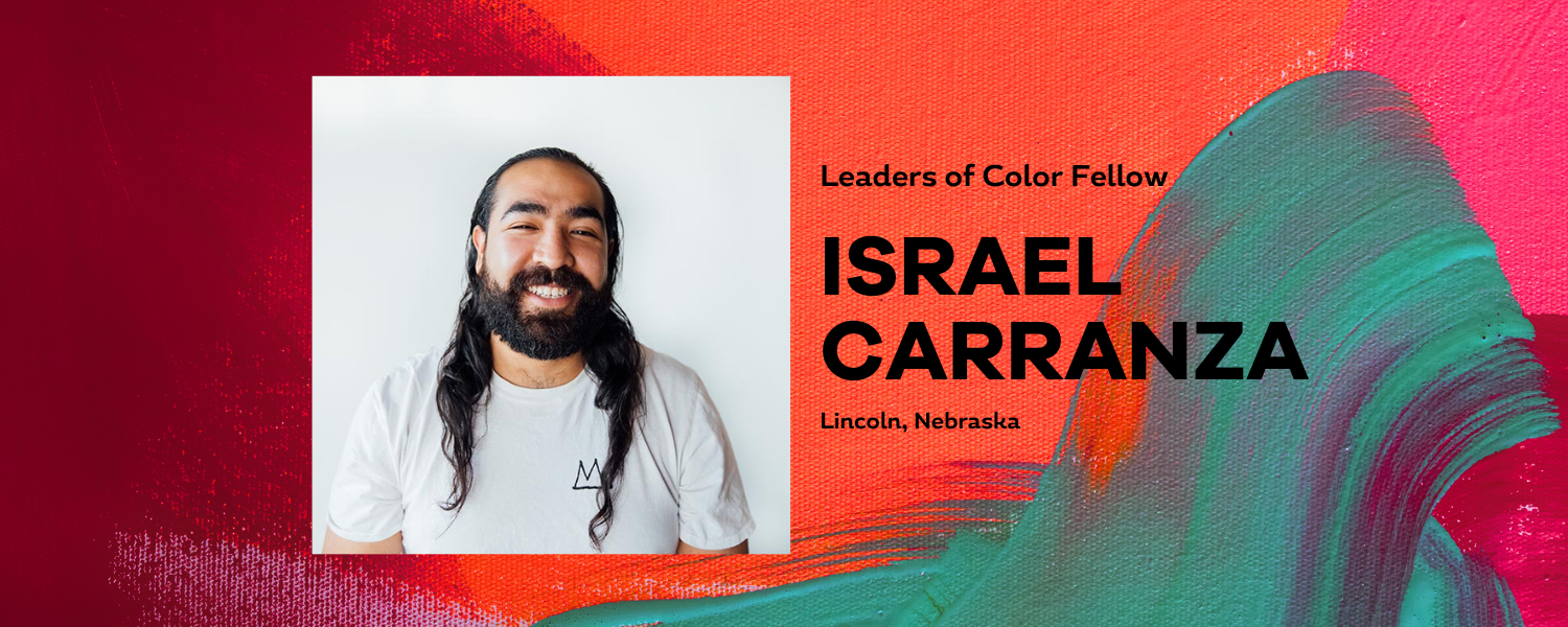 Male presenting individual with long dark hair smiles for a portrait with a white background and painterly red and green background surrounding that. Text states Israel Carranza.