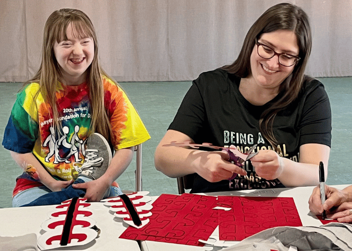 Young girl and woman work on props with fabric.