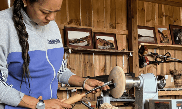 Woman veteran with long braid woodworking Yew Mountain Center